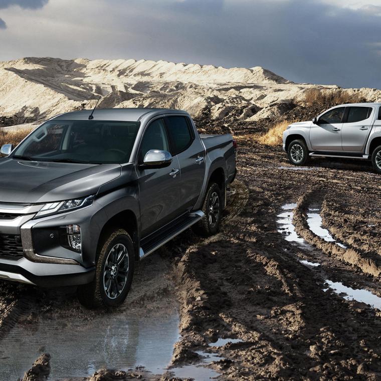 Afbeelding van twee L200's op een bouwterrein